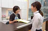 歯科受付から説明を受けている患者様